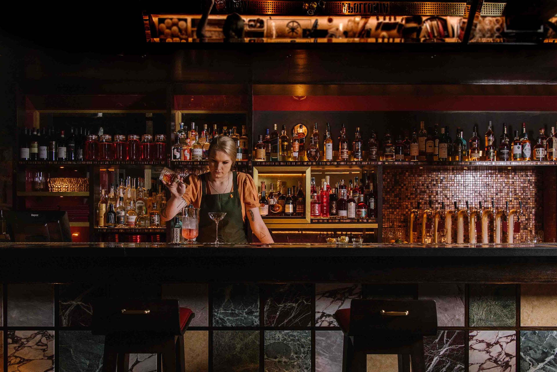 Hinchcliff House bar with dark timber and backlit shelves